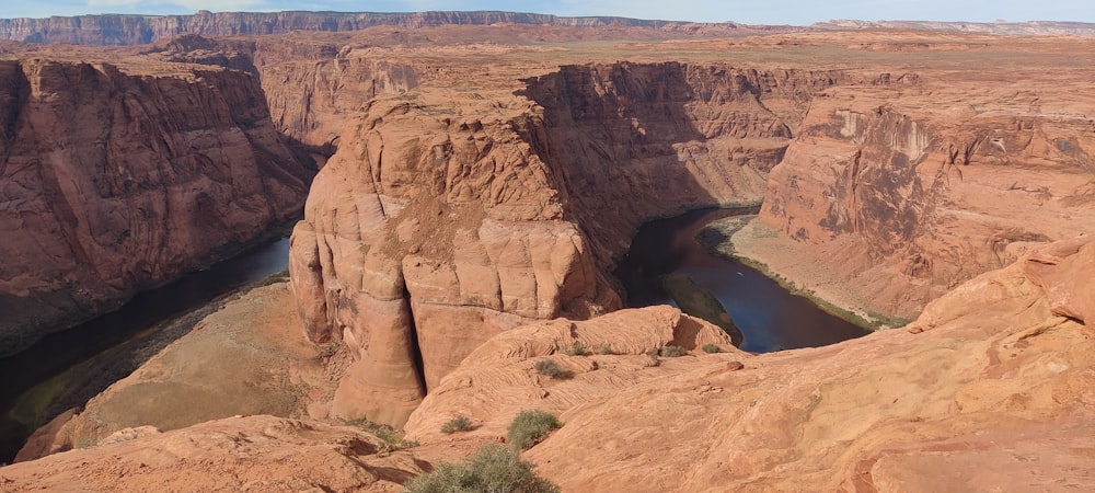 a large canyon with a river running through it with Canyon de Chelly National Monument in the background