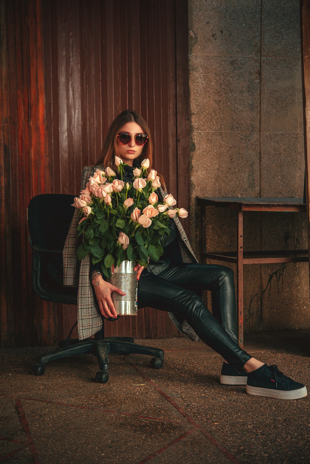 una donna seduta su una sedia che tiene un mazzo di fiori