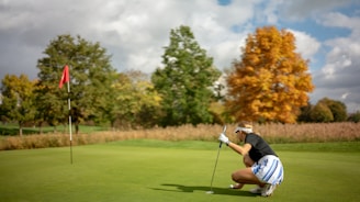A golfer reading a golf blog on a tablet while sitting on a bench near the course.