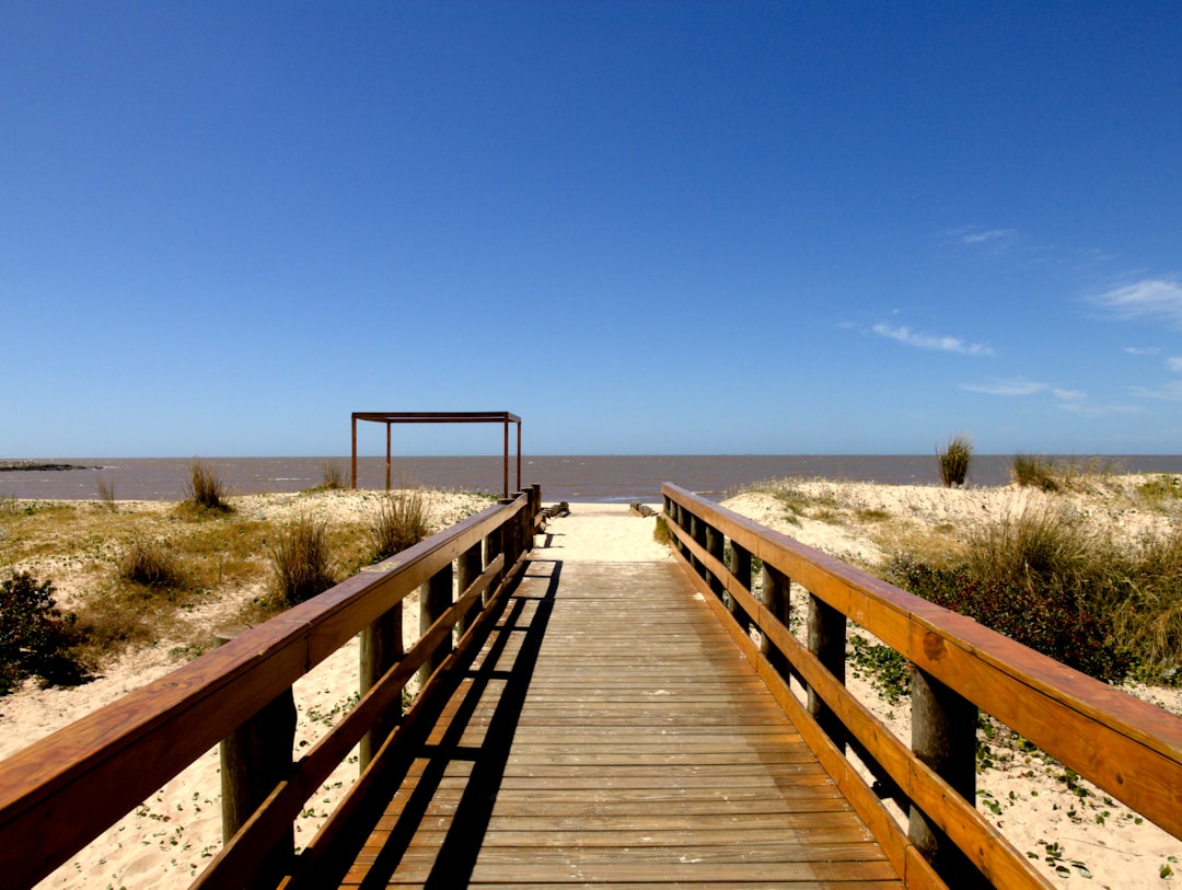 a wooden bridge over a beach,