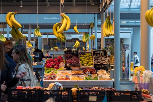 a fruit stand with bananas from the ceiling
