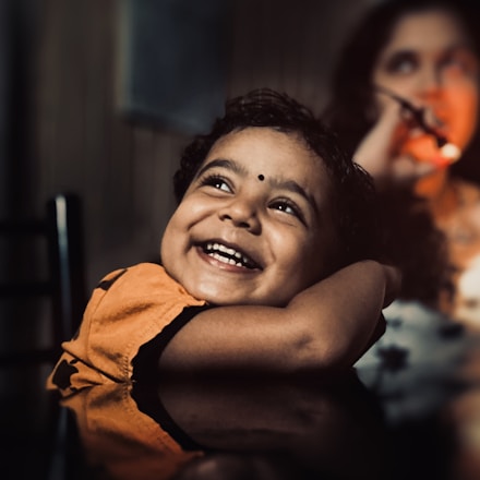 A comforting scene of a child and adolescent smiling during a supportive online therapy session.
