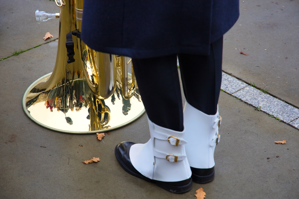 une personne portant des bottes blanches et des bottes noires avec un tuyau attaché