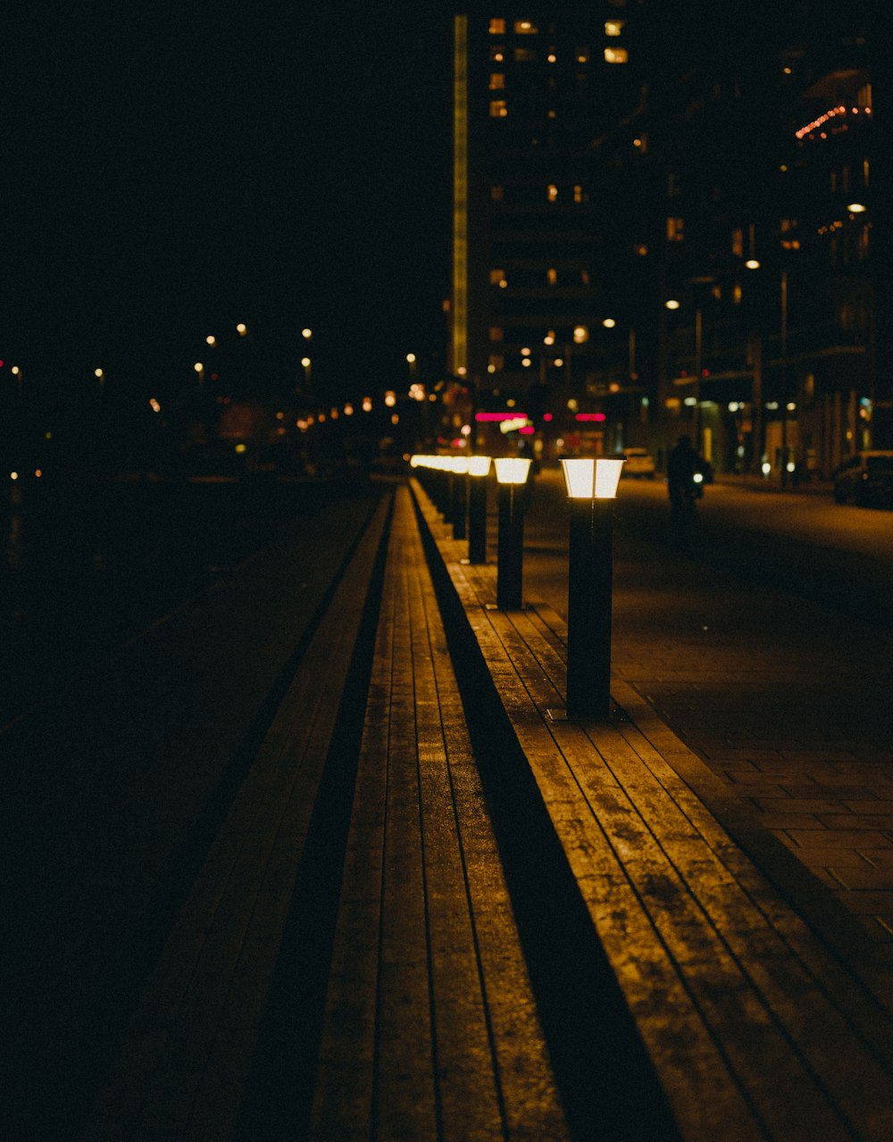 a person walking on a sidewalk at night