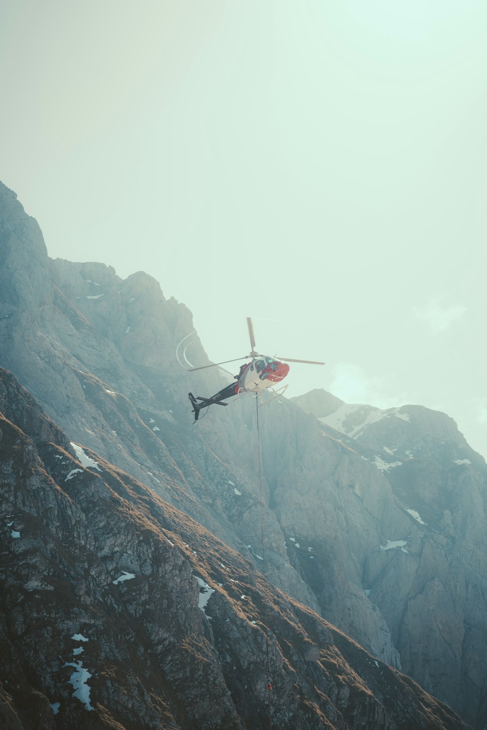 a helicopter flying over a mountain