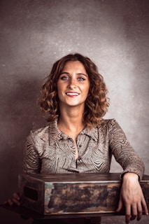 a woman smiling and holding a wooden box