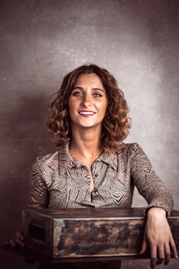 a woman smiling and holding a wooden box