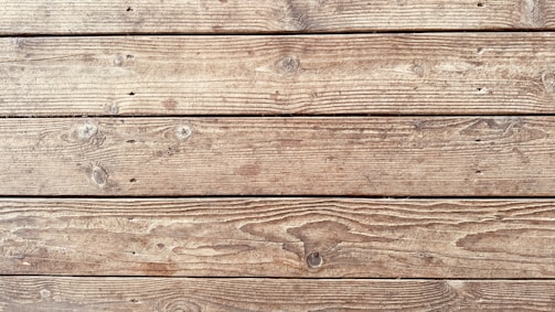 An arrangement of wooden planks featuring a natural texture with visible knots and grain patterns running horizontally.