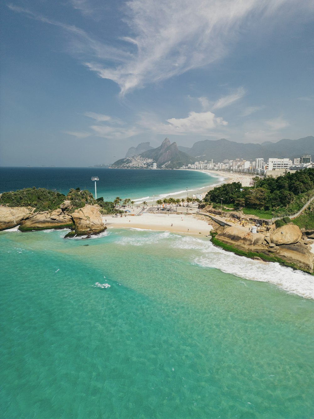 a beach with blue water and a city in the background