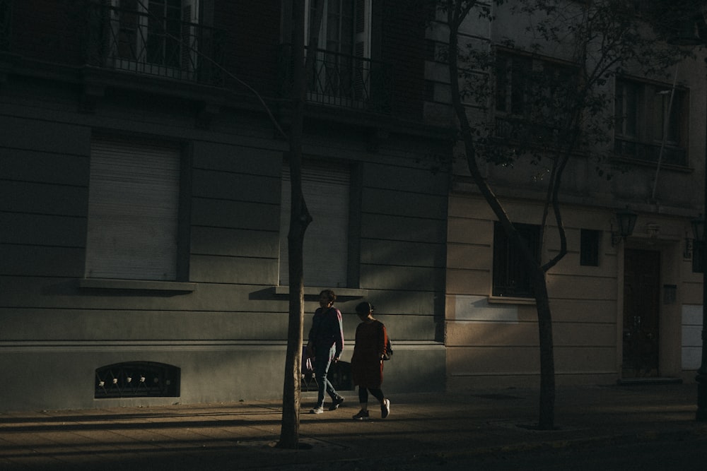 a couple of people walking down a street