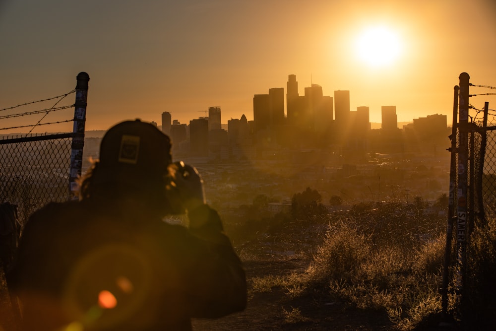 a person standing on a hill with a city in the background