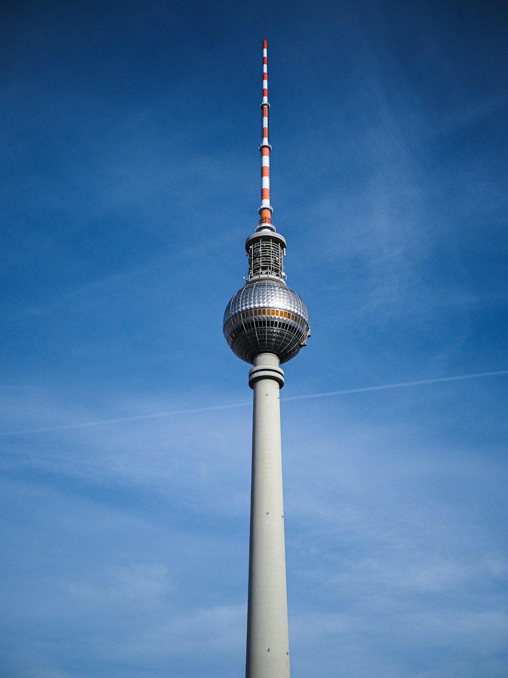 a tall tower with a pointy top with Fernsehturm Berlin in the background