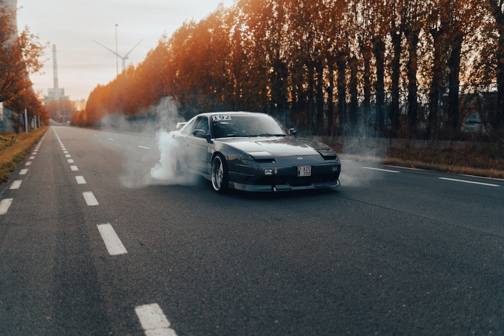 a car driving on a road with smoke coming out of it