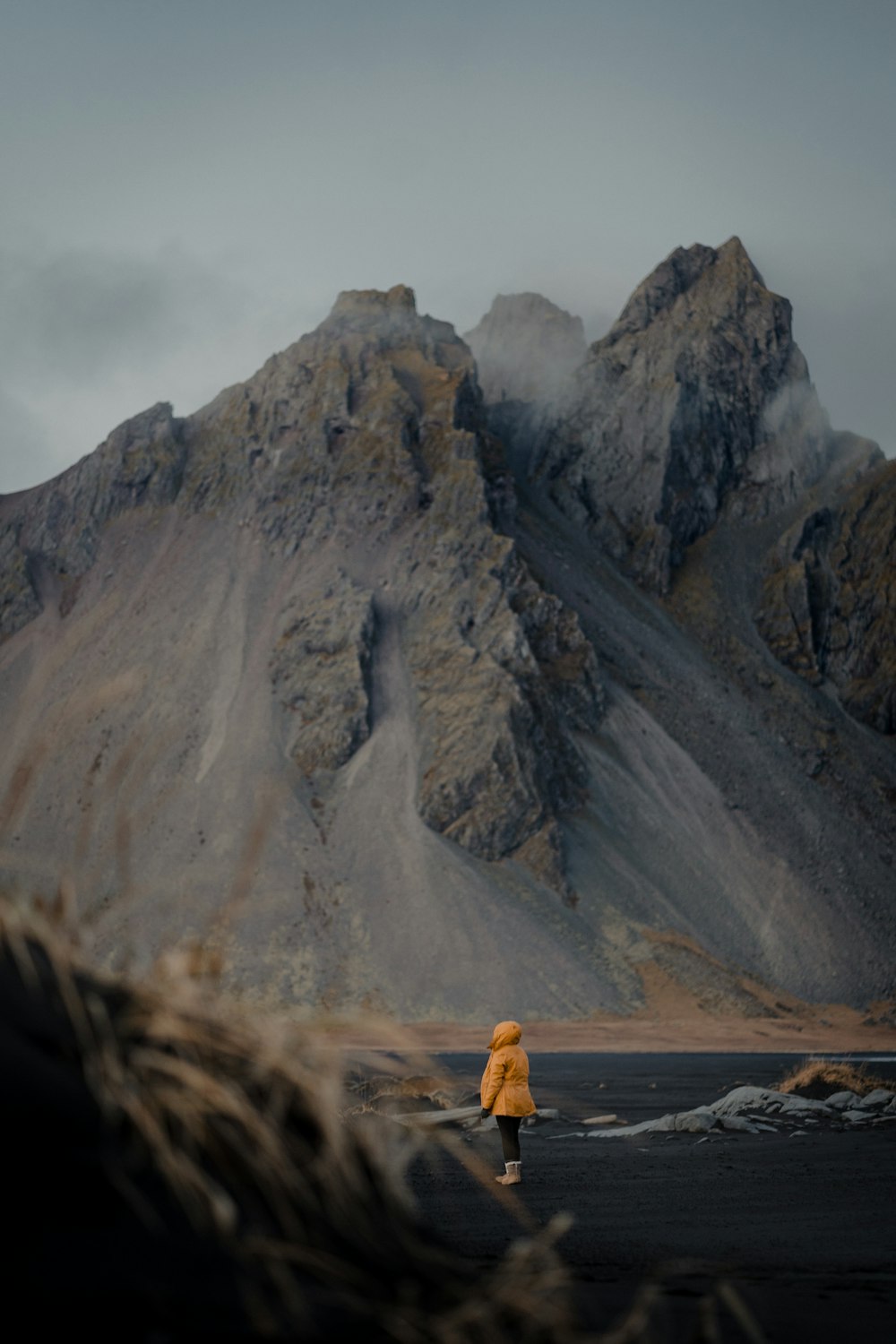 a person walking on a road by a mountain