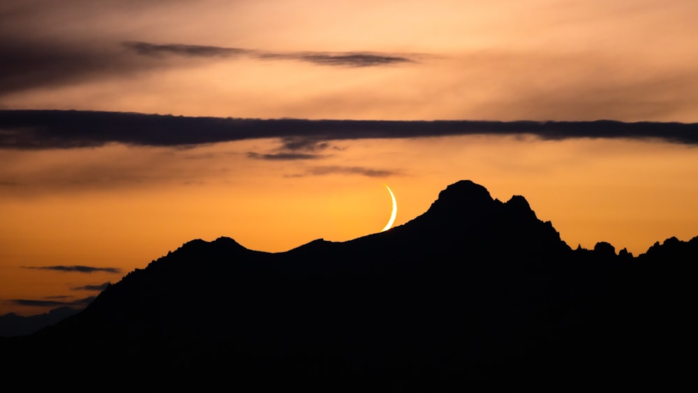 a mountain with a sunset in the background