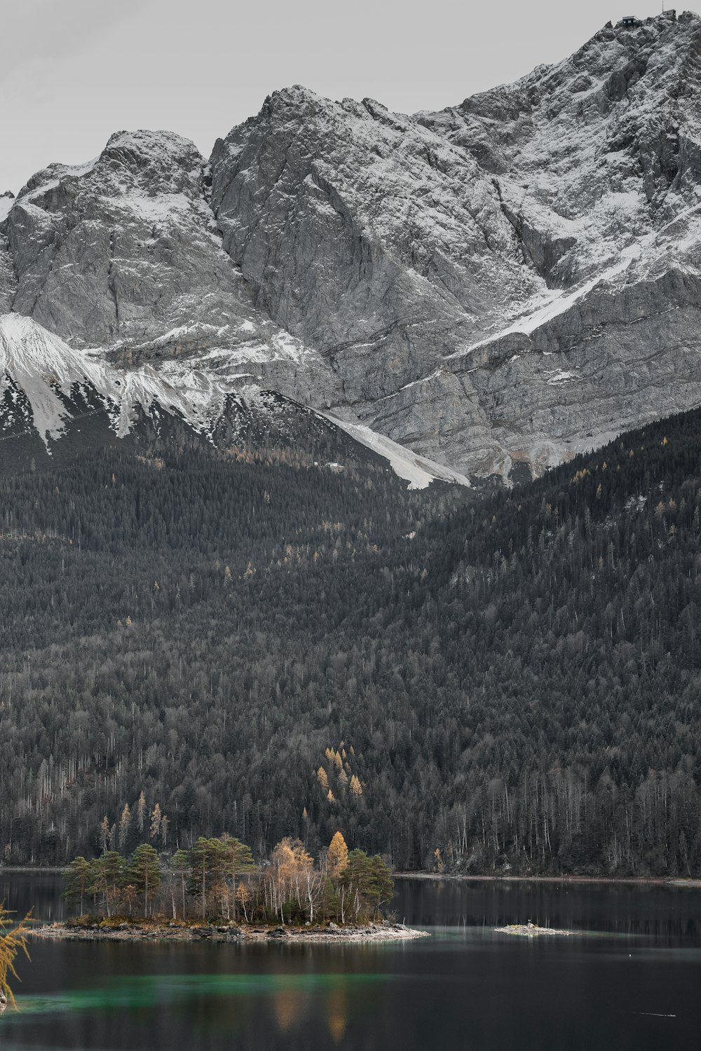 a lake with trees and mountains in the background