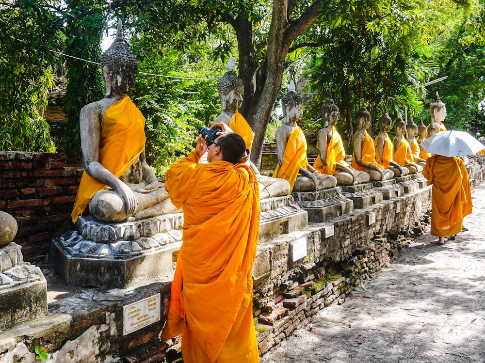 Un homme prenant une photo d’un groupe de statues