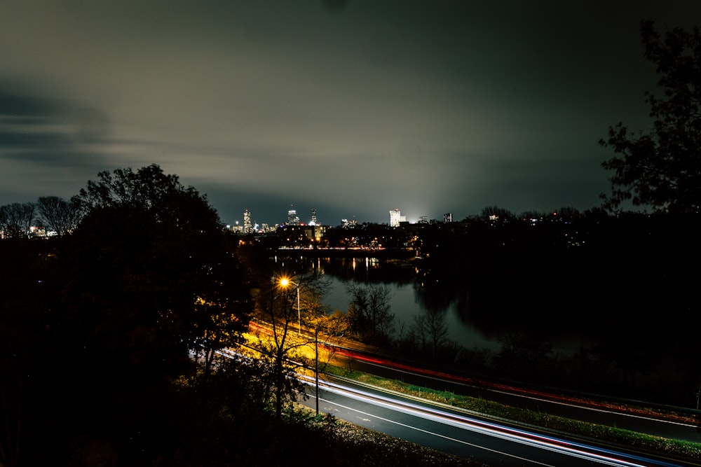 a road with trees and a body of water in the background