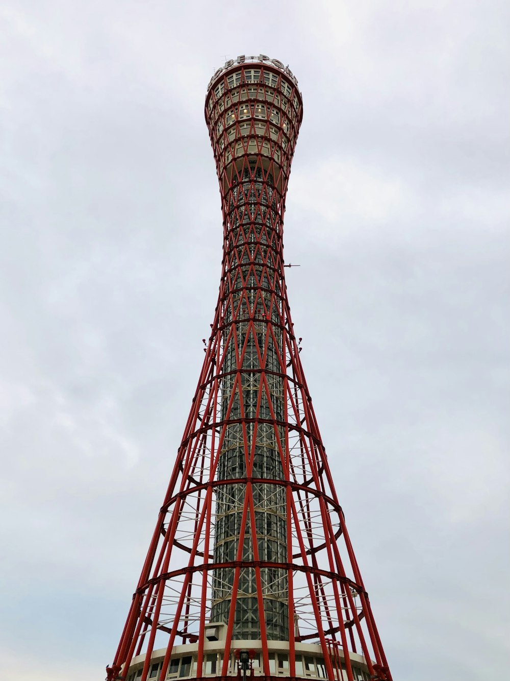 a tall red and white tower with Kobe Port Tower in the background