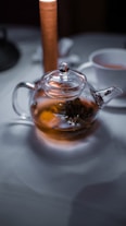 a glass jar with a brown liquid and a spoon in it