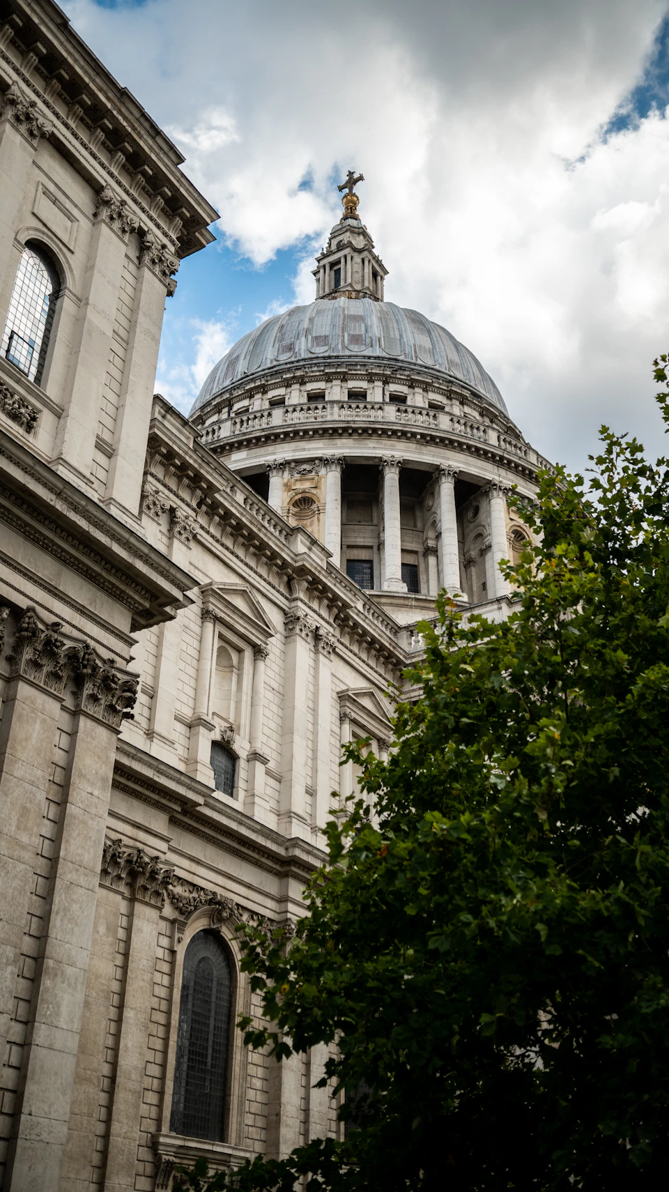 Majestic stone building with dome and columns stands tall against an overcast sky backdrop