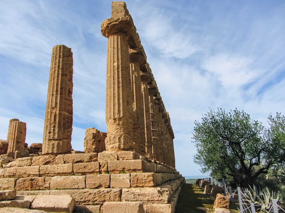 uma estrutura de pedra com pilares com Agrigento ao fundo