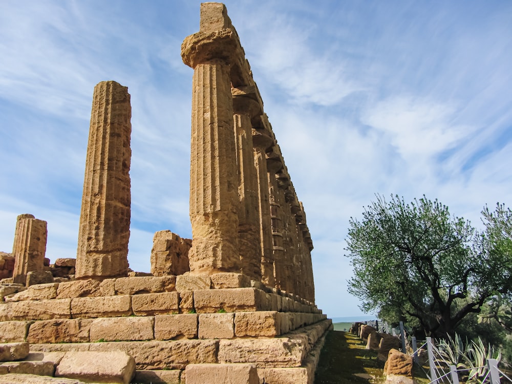 a stone structure with pillars with Agrigento in the background