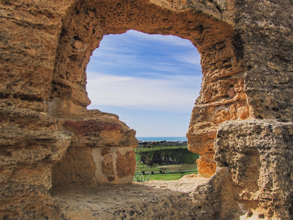 a view of a landscape through a stone window
