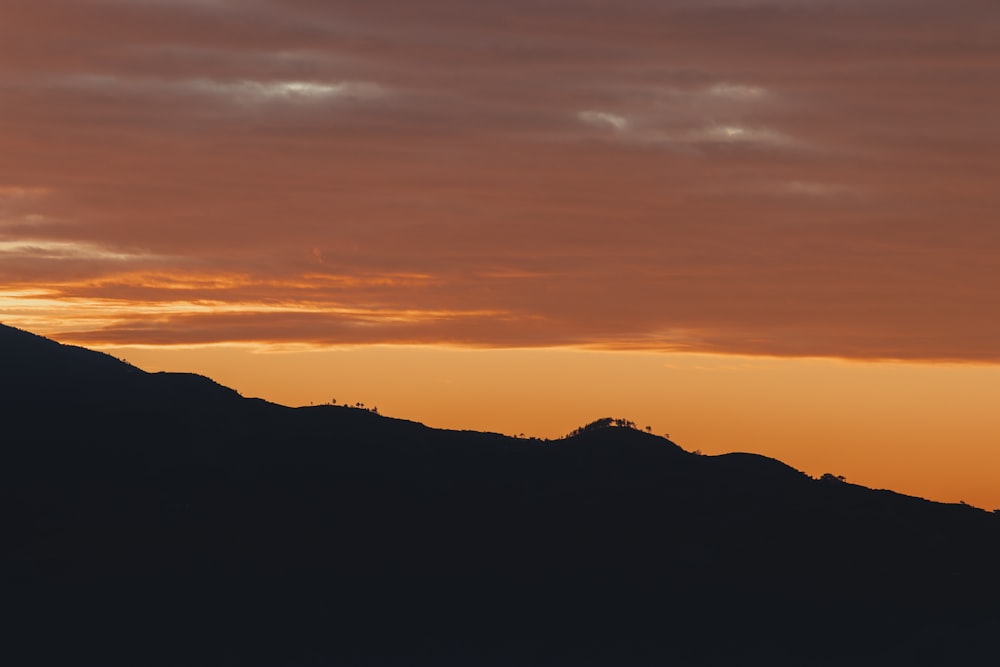 Una montagna con un tramonto sullo sfondo