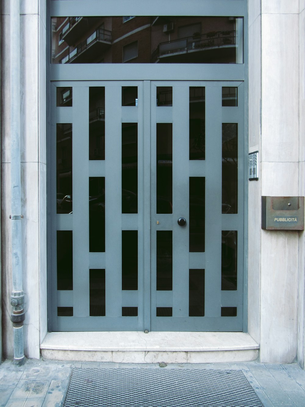 a blue gate with a building in the background