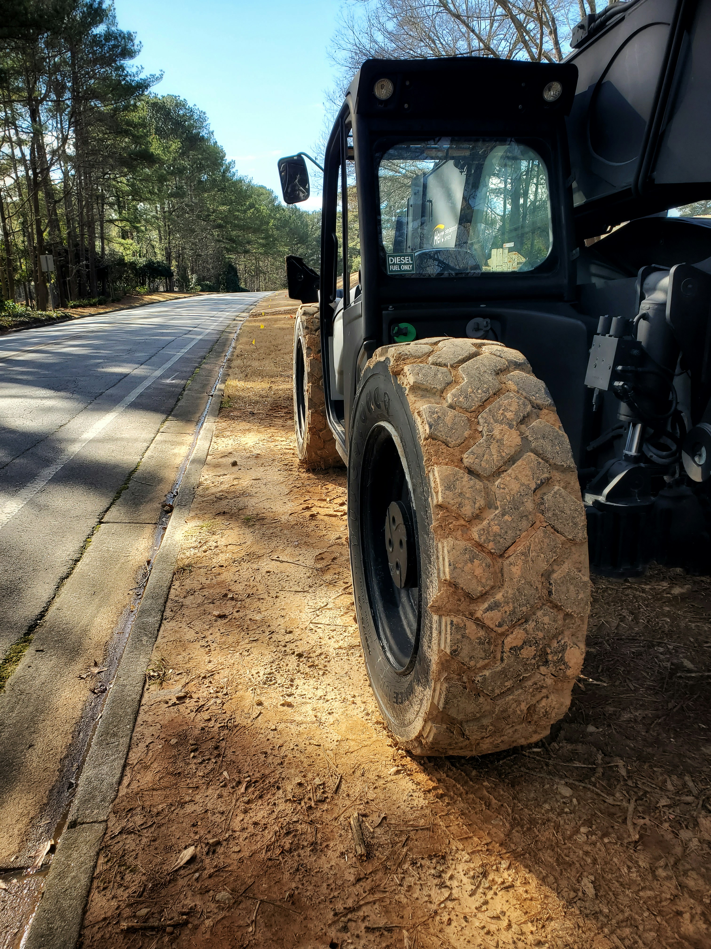 a black truck with a large flat tire on the side of the road