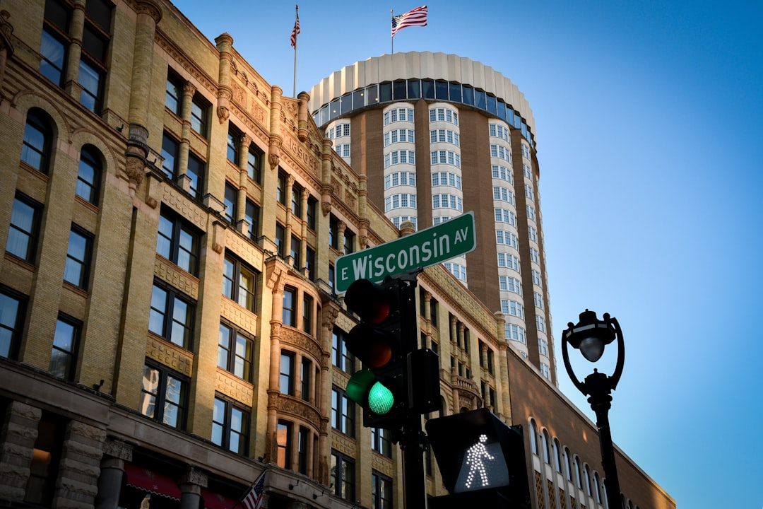 a traffic light in front of a large building, View of the Pfister Hotel from an East Wisconsin Avenue crosswalk