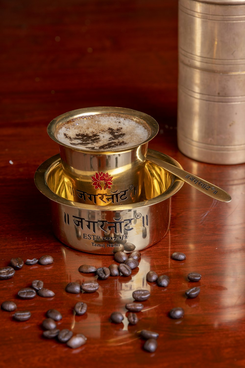 a metal coffee maker with coffee beans