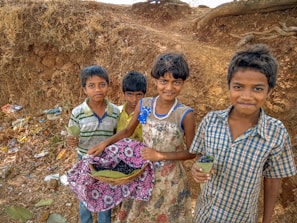 Smiling kids enjoying fresh fruit kebabs outside on a bright day surrounded by greenery.