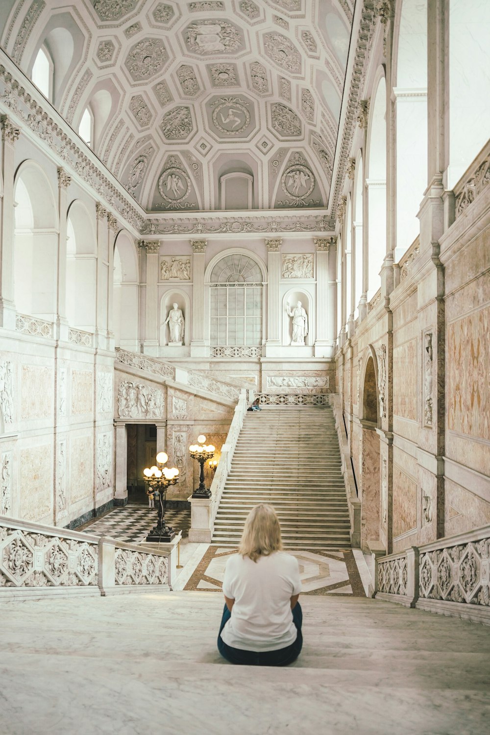 a person sitting on the floor of a large ornate building