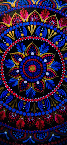 Detail of a mandala design with gold foil patterns glowing against a deep blue backdrop.