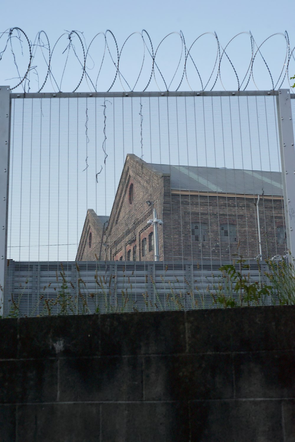 a fenced in area with a building in the background