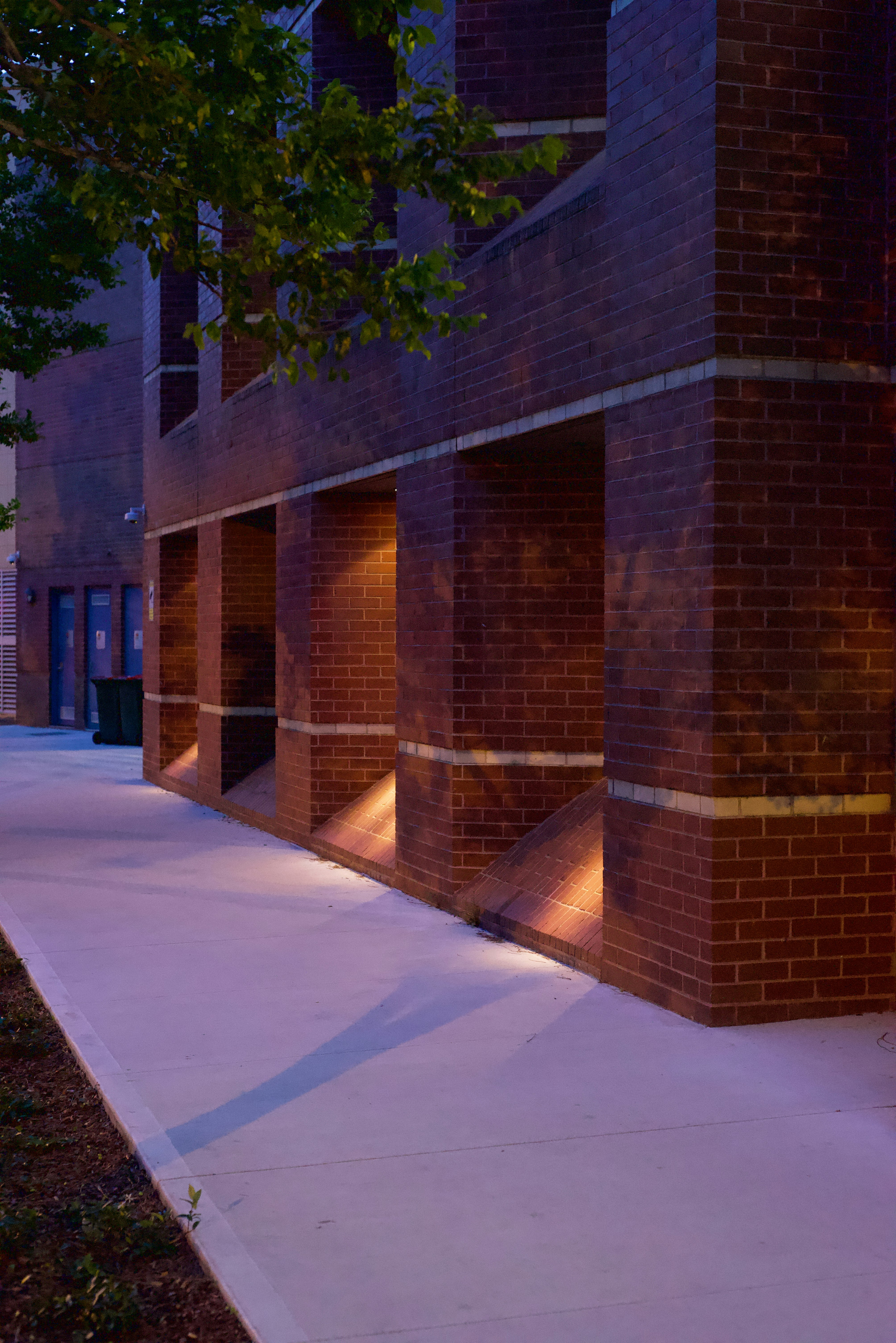 A brick building with a sidewalk photo – Free Dark Image on Unsplash