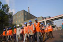 a group of people wearing orange vests and helmets