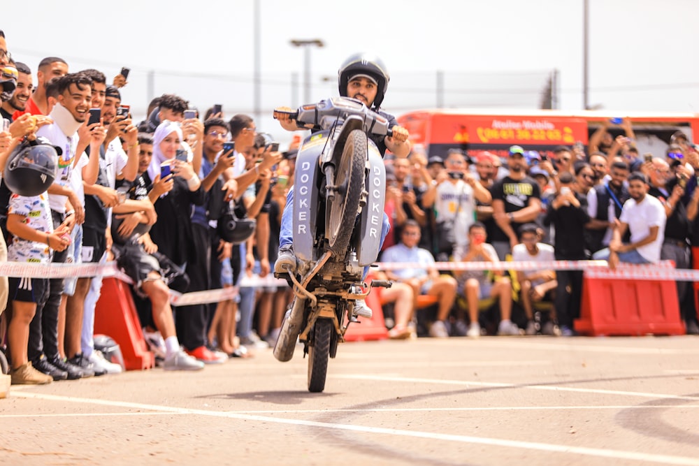 a person on a motorcycle in front of a crowd