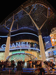 A bustling commercial complex with glass facades and people entering and exiting.