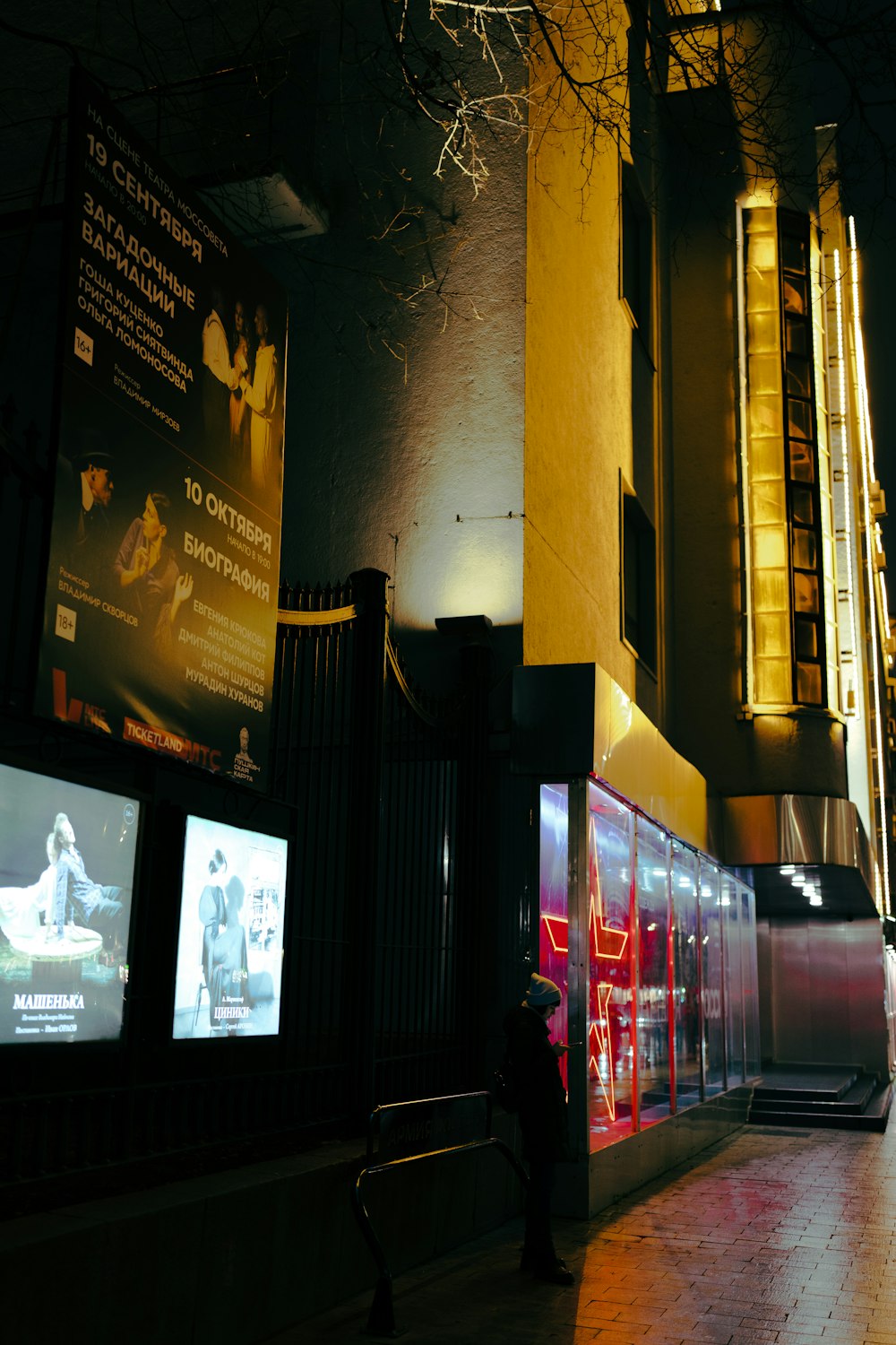 a person standing next to a row of televisions