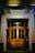 A beautifully designed wooden door with intricate details, set against a bright, inviting home entrance.