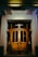 A beautifully designed wooden door with intricate details, set against a bright, inviting home entrance.