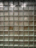 Multiple glass block lamps displayed on a concrete shelf, highlighting their textures.