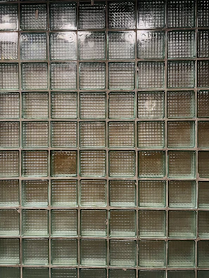 Multiple glass block lamps displayed on a concrete shelf, highlighting their textures.