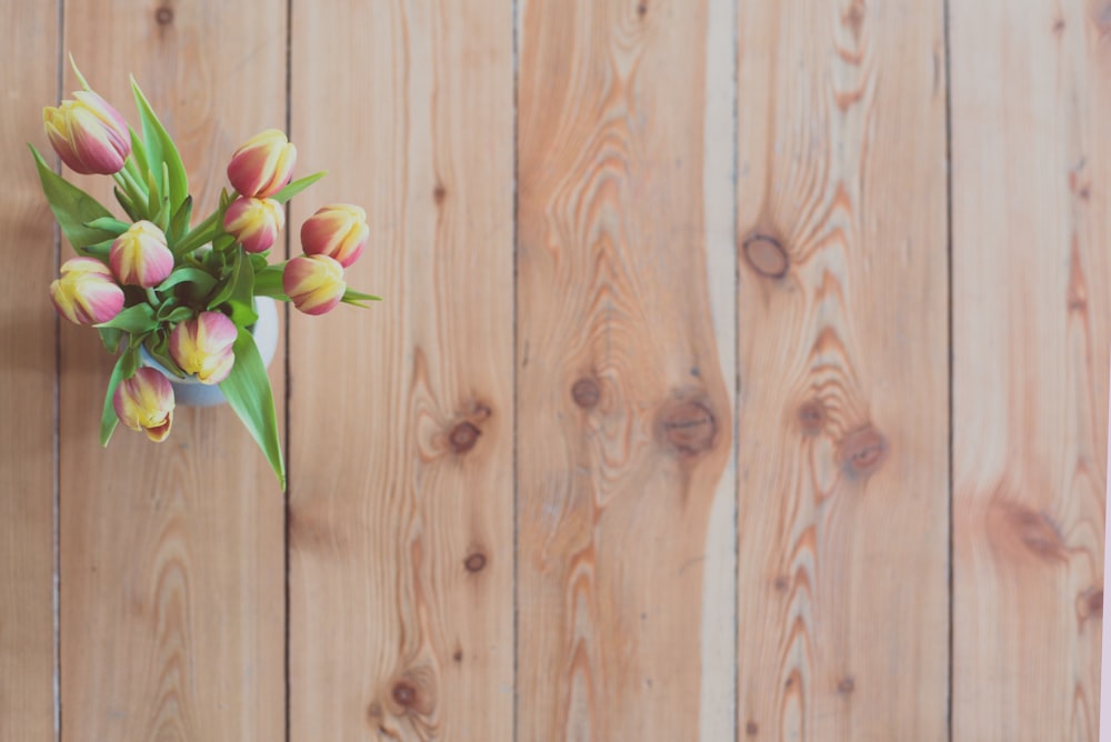 a group of flowers on a wooden surface