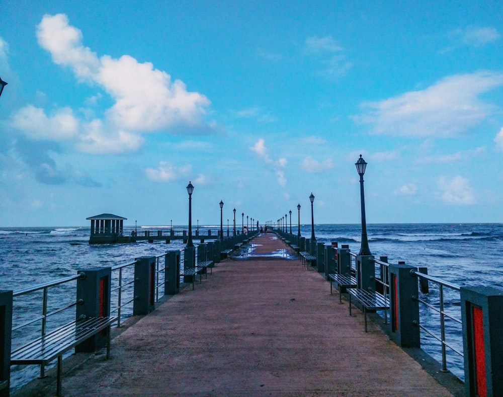 a walkway with lights on it next to a body of water