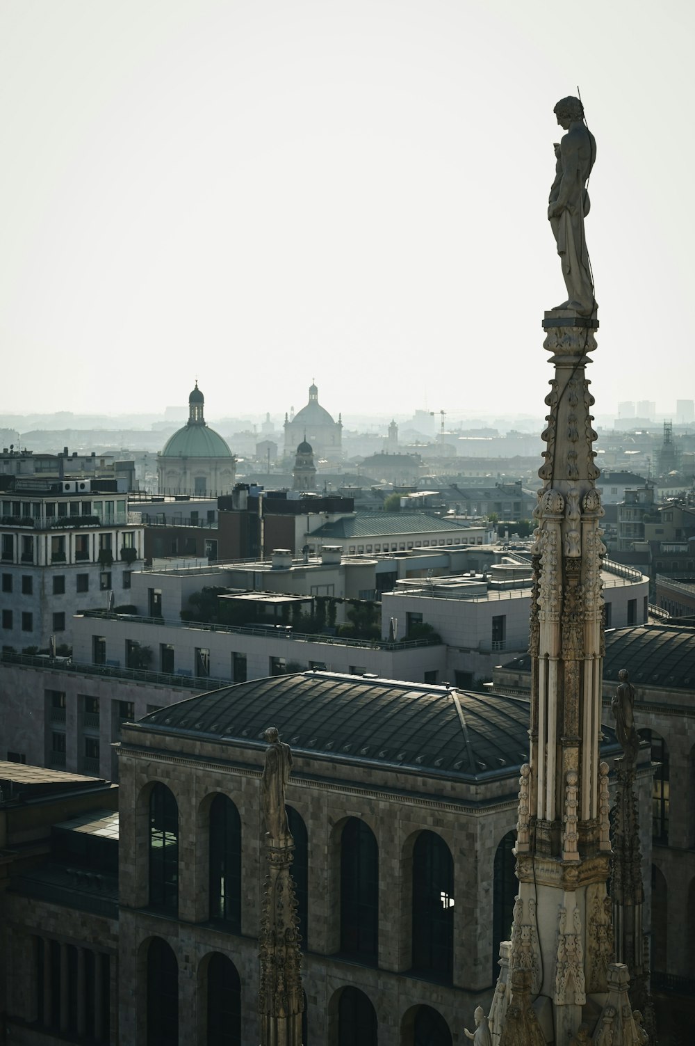 a statue on a pole in front of a city