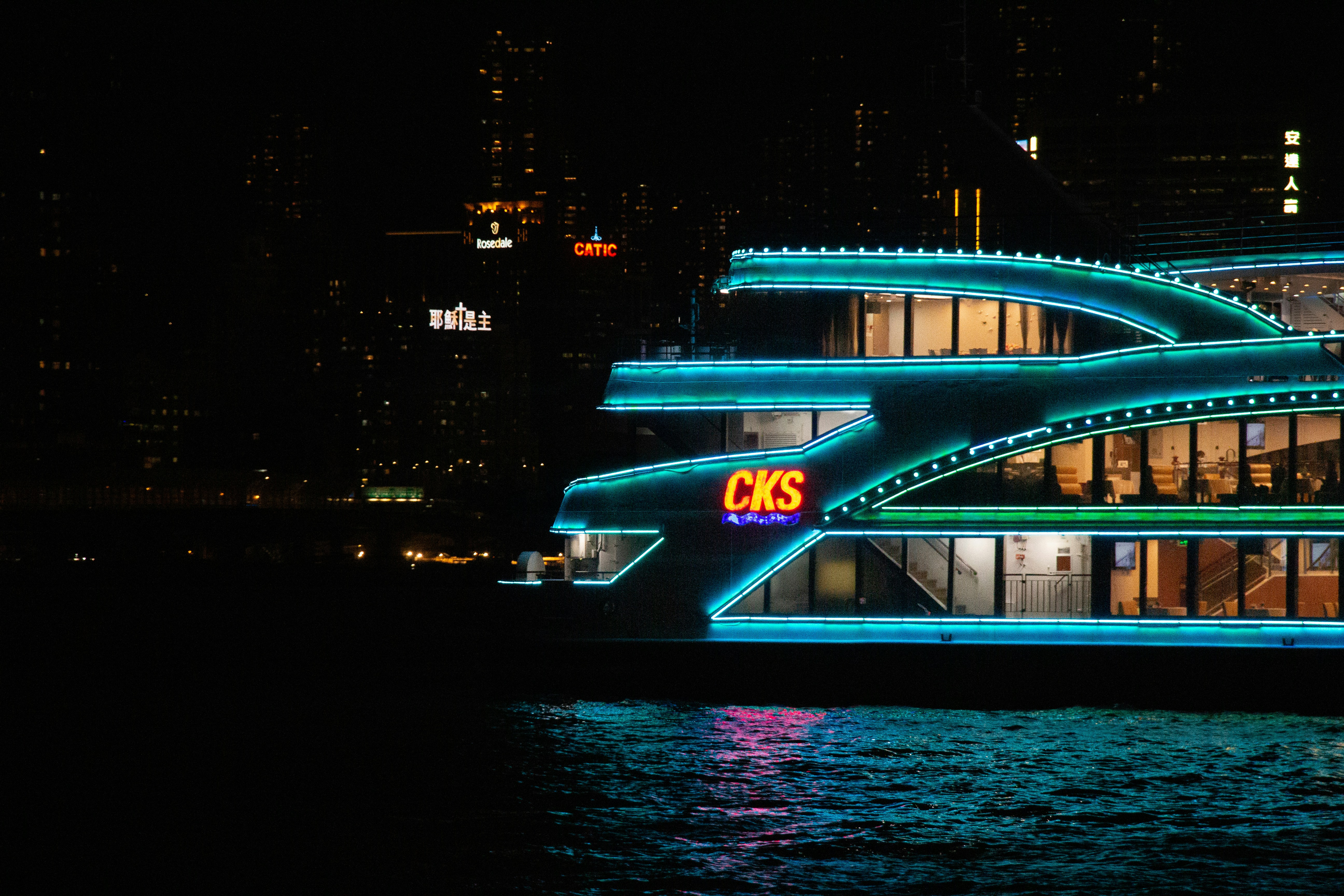 a building with a sign on it by water at night
